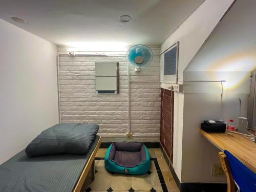 迈索尔Rahee Bi Roambay - Backpacker Hostel的小房间设有一张床和一张书桌