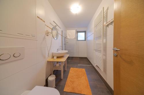 阿尔滕马克特蓬高雪绒花公寓的白色的浴室设有水槽和卫生间。