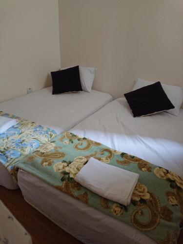 巴特沃思Butterworth Seaside view Family spacious的客房内的两张床和黑色枕头