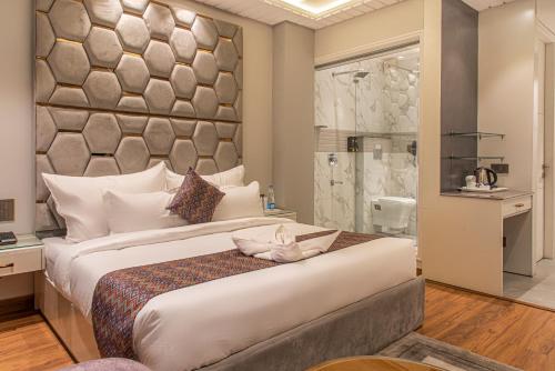 西姆拉AnantVilas Shimla Hills的一间卧室设有一张大床和淋浴