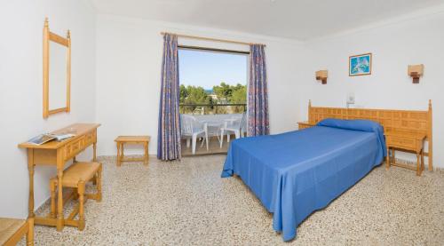 圣安东尼奥湾巴伊亚普拉亚酒店的一间卧室配有蓝色的床和桌椅