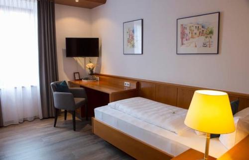 希明格加斯托夫苏奥柏威尔特酒店的酒店客房配有一张床和一张带黄灯的书桌