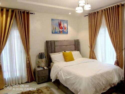 莱基HOMEDALES Freedom Way LEKKI Phase1 LAGOS的一间卧室配有带白色床单和黄色枕头的床。