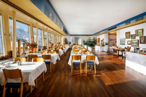维尔德豪斯Hirschen Guesthouse - Village Hotel的餐厅设有白色的桌椅和窗户。