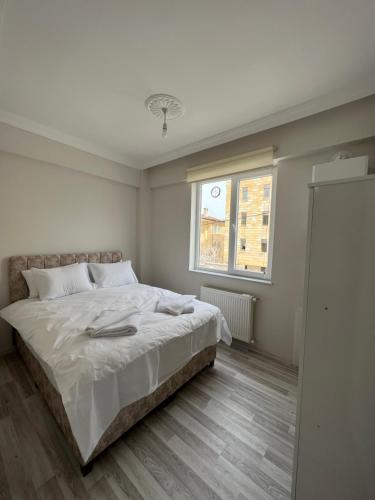 于尔居普Cappadocia 4 Luxury Aparts的白色的卧室设有床和窗户