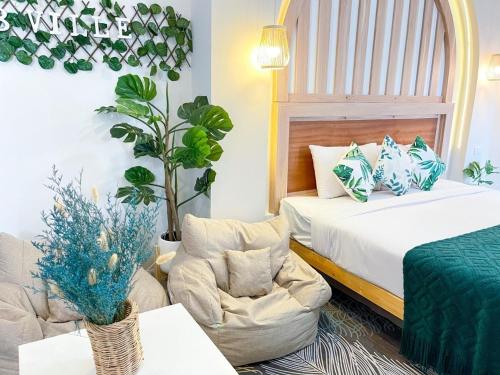 曼谷廊曼机场威乐48公寓式酒店的一间卧室配有一张床、一张沙发和一把椅子