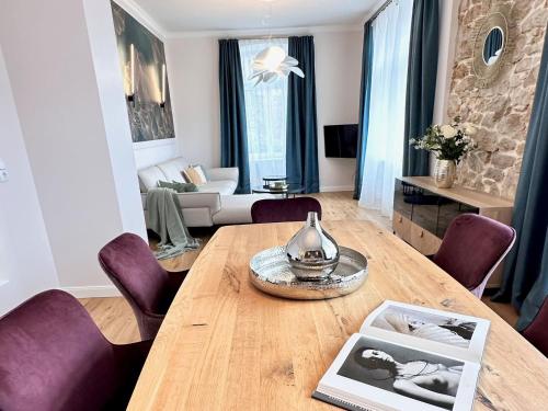 巴登韦勒Villa Gloria的客厅配有木桌和紫色椅子
