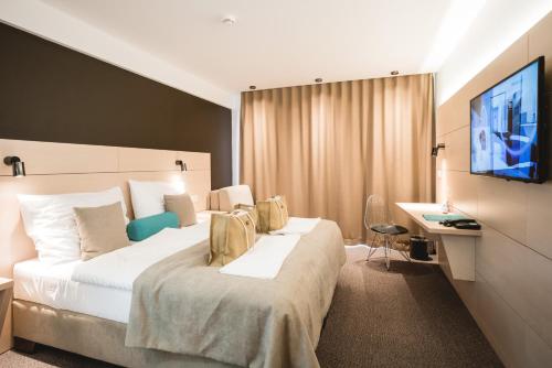 卡鲁扎Hotel Thermal ŠÍRAVA的酒店客房设有一张大床和一台电视。