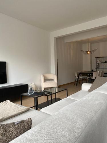 莫尔特塞尔Cosy Apartment near Antwerp的一间带白色家具的客厅和一间餐厅