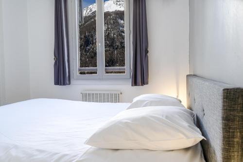 莱索尔Les Anémones 6 places的一间卧室配有一张带白色床单的床和一扇窗户。