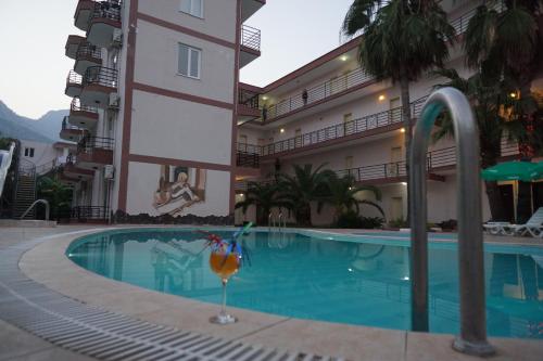 BeldibiAybel İnn Hotel的一座酒店游泳池,旁边是一座建筑