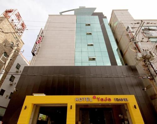 蔚山Hotel H2的酒店大楼前面有一个黄色的门