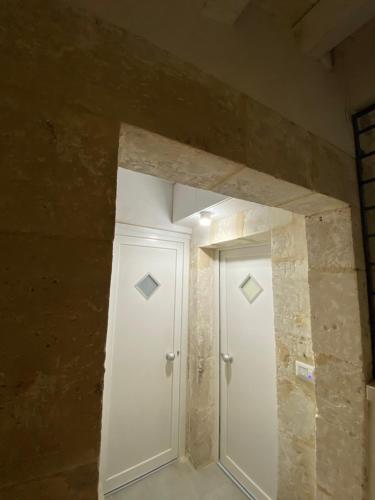 锡拉库扎Casa 68 Ortigia的一间设有白色门和石墙的房间