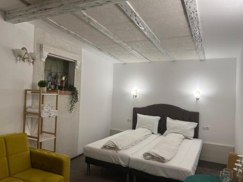 巴克乌Sport Residence的一间卧室配有一张床和一张黄色椅子