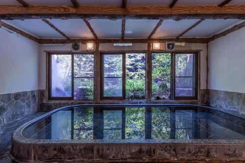 箱根伊其挪揄宏坎酒店的一座带窗户的室内泳池