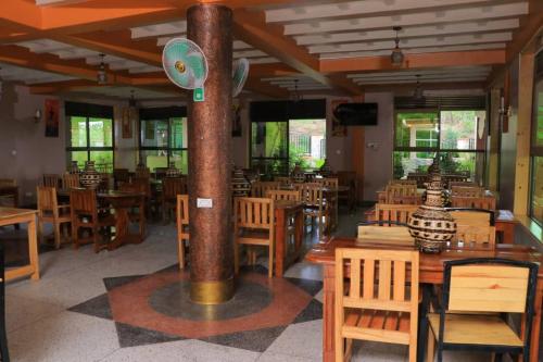 姆巴拉拉Dreamwood suites Mbarara的用餐室配有木桌和椅子