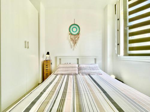 普罗普里亚诺U Paradisu - Balcon - 100m mer - Parking - Climatisation的卧室配有一张床,墙上挂着一个钟