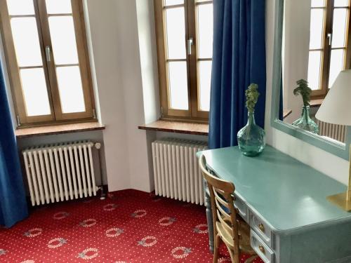 施坦贝尔格湖畔贝格Strandhotel Berg的窗户房间里一张带花瓶的桌子