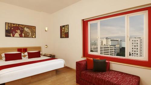 海得拉巴海得拉巴高科技城红狐狸酒店的一间卧室设有一张床、一个窗口和一把椅子
