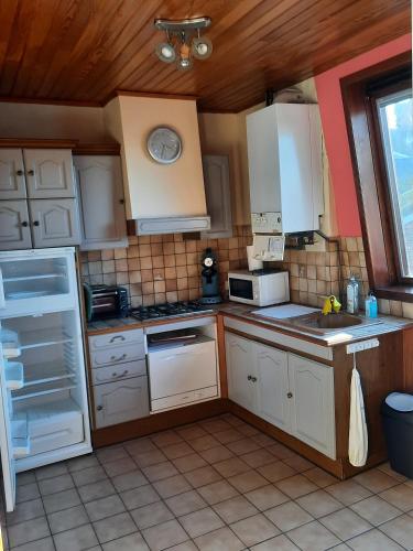 勒特雷波尔le pigeonnier的厨房配有白色橱柜和白色家电