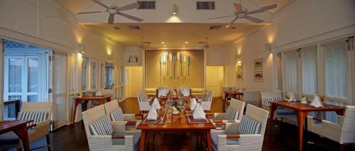 华欣盛泰澜华欣海滩别墅及度假村的一间带桌子和白色椅子的用餐室以及天花板