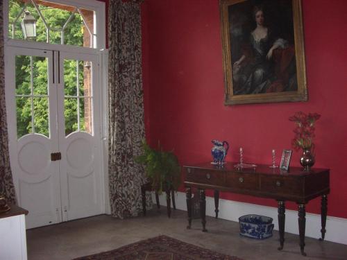 Muston格里布豪斯穆顿酒店的一间设有桌子、绘画和门的房间