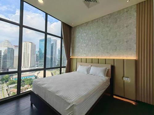 雅加达Senopati Penthouse Luxury 2 Bedroom Full Furnished SCBD Area的一间卧室设有一张大床和大窗户