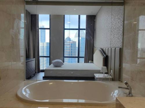雅加达Senopati Penthouse Luxury 2 Bedroom Full Furnished SCBD Area的大型浴室设有大浴缸和床。