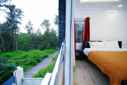 埃尔加德GV Resort的一间卧室配有一张床,阳台设有窗户