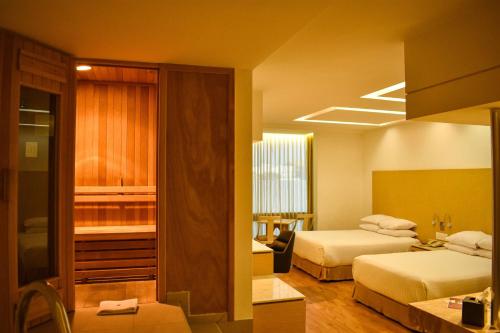 墨西哥城Ramada by Wyndham Mexico City Santa Fe的酒店客房带两张床和一间浴室