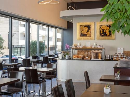 洛迦诺宜必思洛迦诺酒店的餐厅设有桌椅和窗户。