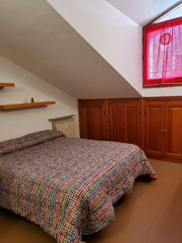 圣文森特Mansarda Via Chanoux的一间卧室设有一张床和一个窗口