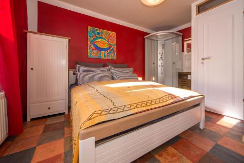 富伦多夫Fischohr - Studio的一间卧室设有一张带红色墙壁的大床