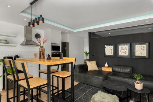 开普敦The Iron Works Apartments的厨房以及带桌子和沙发的客厅。