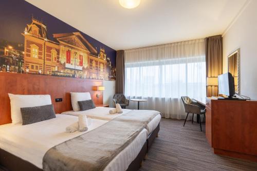 阿姆斯特丹阿姆斯特丹新西酒店的酒店客房设有两张床和电视。