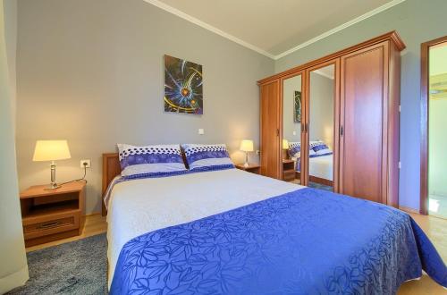 波拉特Apartments Mira的一间卧室配有一张蓝色大床和镜子