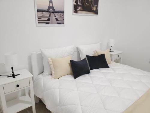 捷尔诺波尔VINNA Просторі апартаменти в новобудові.的一间卧室配有一张带枕头的白色床和艾菲尔铁塔。