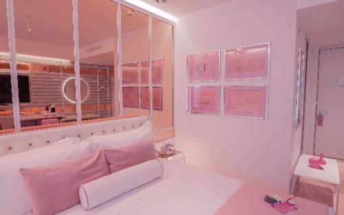 米兰ODSweet Duomo Milano Hotel的一间卧室配有一张带粉红色枕头和镜子的床
