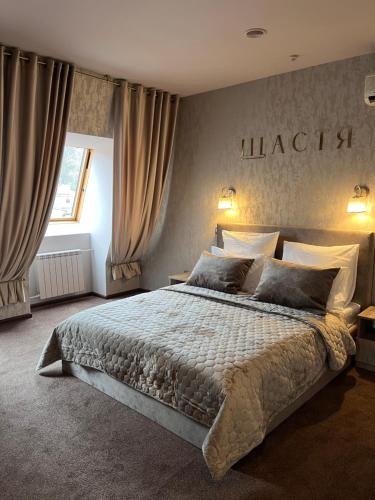 波尔塔瓦Готельно-ресторанний комплекс Щастя的卧室配有一张大床,墙上挂着 ⁇ 指