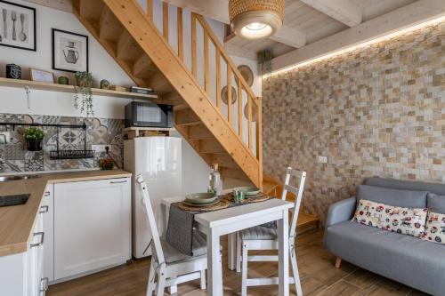 夸尔图-圣埃莱娜Loft 35 - private parking的厨房以及带小桌子和椅子的客厅。