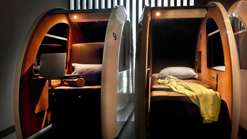迪拜sleep 'n fly Sleep Lounge, A-Gates Terminal 3 - TRANSIT ONLY的小房间设有双层床和笔记本电脑