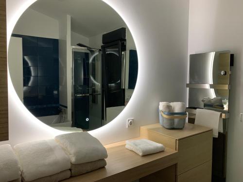 尼姆Agréable maison de ville clim/piscine/jardin的浴室设有大镜子和带水槽的长凳