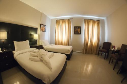 瓦迪穆萨拉麦迅酒店的酒店客房带两张床和一张桌子以及椅子。