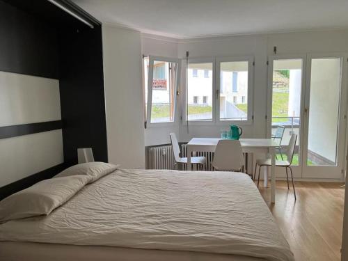 圣莫里茨Ferienapartment in Bestlage in Sankt Moritz的卧室配有一张床和一张桌子及椅子