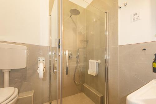 巴勒莫Hotel City Center的浴室设有玻璃淋浴间和卫生间