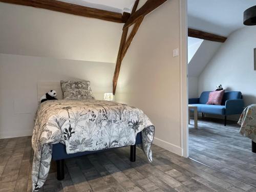 谢尔河畔努瓦耶Maison n°4 aux portes du Zoo de Beauval的一间卧室配有一张床和一张蓝色的沙发