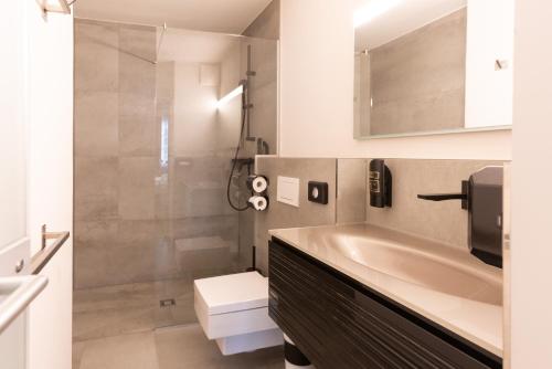 萨尔茨堡Boutiquehotel am Dom的浴室配有盥洗盆、卫生间和浴缸。