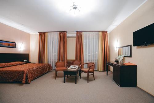 苏尔古特梅特里萨酒店的酒店客房带一张床、一张桌子和椅子