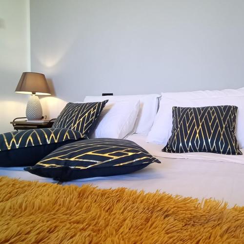 维泰博ArtGallery Apartment - Villa immersa nel verde - Deluxe的一张带黑白枕头的床和一盏灯