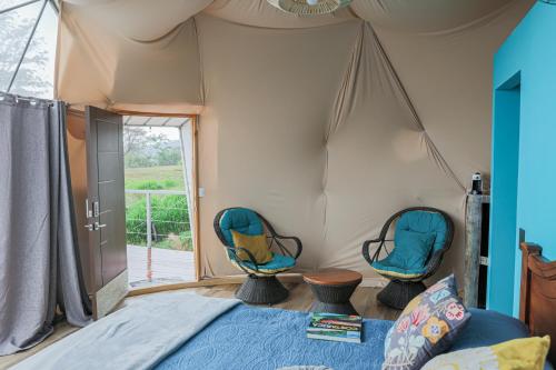 SantiagoBadu Lodge Puriscal的帐篷内一间卧室,配有两把椅子